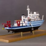 A full side view of the engineering scale model of the RV Sikuliaq showing a crane operation
