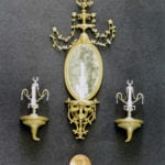 Detail view of a museum scale model of a tiny mirror and sconces created for the Rosalie Whyel Museum with a penny coin for scale