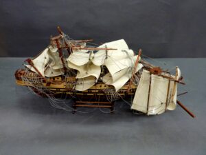 Full view of the damaged ship model.